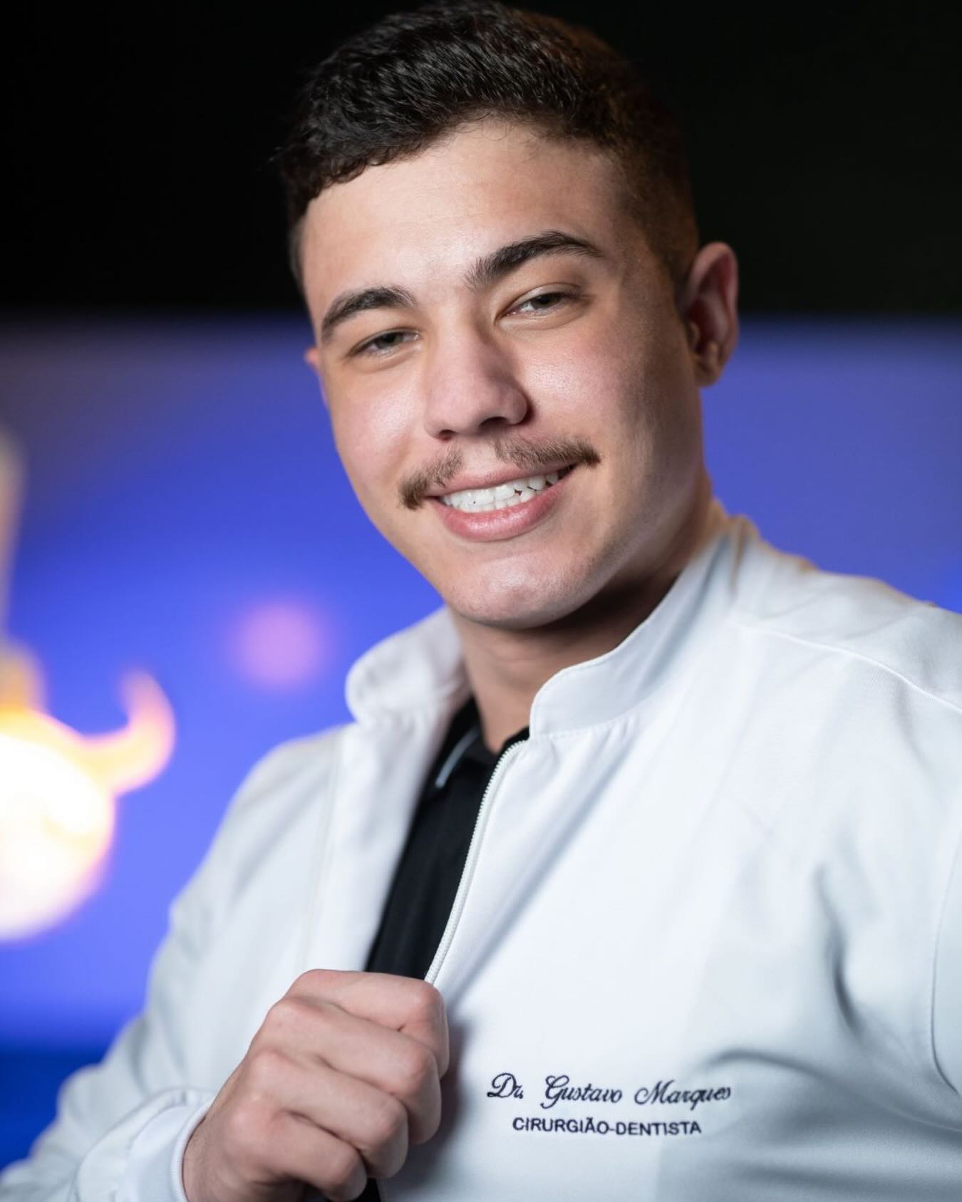 Dr. Gustavo Marques Carvalho, cirurgião-dentista, sorrindo de jaleco branco